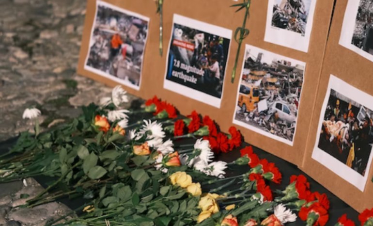 Flowers laid next to information about the earthquake