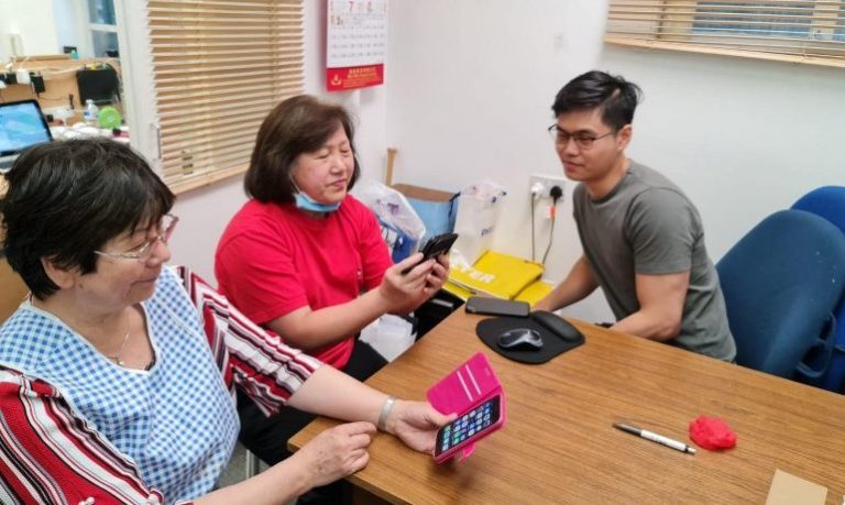 Three people discussing how to use a phone app